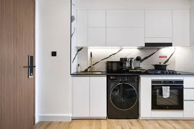 a white kitchen with a dishwasher and a washer at Luxury Studio with Private Jacuzzi in Business Bay in Dubai