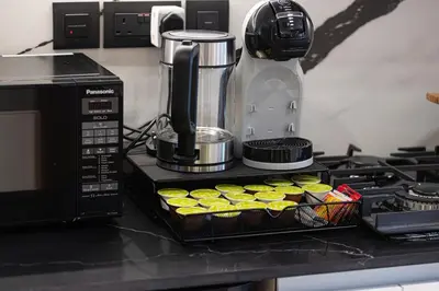 a kitchen counter with a microwave and a tray of cupcakes at Luxury Studio with Private Jacuzzi in Business Bay in Dubai