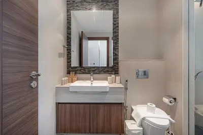 a bathroom with a sink and a toilet and a mirror at 3BR with Burj Khalifa View - Pool - Gym - Downtown in Dubai