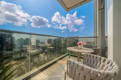 a balcony with a table and chairs and a view of the city at Skyline View Stu 20th Floor Regina Tower, JVC in Dubai