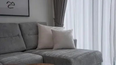 a couch with a pillow sitting next to a window at Creek Vista Elegance-1BRBurj Khalifa View in Dubai