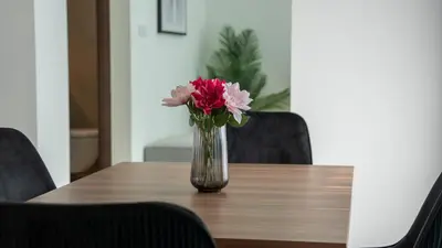 a vase of flowers sitting on a wooden table at Creek Vista Elegance-1BRBurj Khalifa View in Dubai