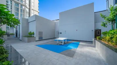 a white building with a blue pool in a courtyard at Creek Vista Elegance-1BRBurj Khalifa View in Dubai