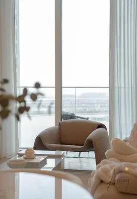 a living room with a couch and a large window at Elite Beachfront Living Stylish High-Floor 1BR in Dubai