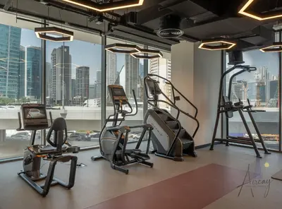 a gym with cardio equipment and a view of the city at Burj Khalifa View Luxe 1BR Paragon by IGO in Dubai