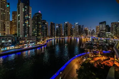 a city skyline at night with a river and buildings at Modern Marina-View 3 BR Prime Waterfront in Dubai