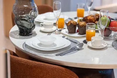 a table with plates of food and glasses of orange juice at Ritz 1BR Vida Dubai Mall Hotel Amenity & Mall Access in Dubai