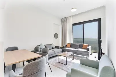 a living room with a couch and chairs and a table at Cozy 1BR Apartment, 20 Min to Jebel Ali Beach in Dubai