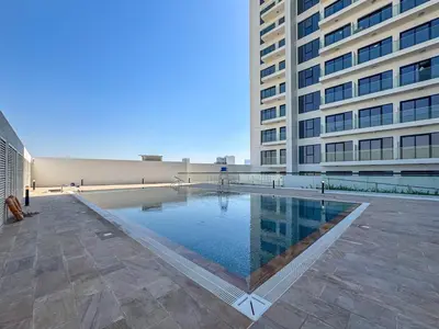 a swimming pool in the middle of a building at Cozy 1BR Apartment, 20 Min to Jebel Ali Beach in Dubai