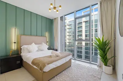 a bedroom with a bed and a large window at Cozy 1BR at D1 Residence 13 with Stunning City View in Dubai
