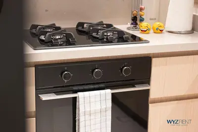 a black stove top oven with a towel hanging from it at Posh 2BR Vida Dubai Mall Hotel Amenity & Mall Access in Dubai