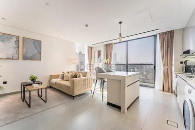 a kitchen and living room with a couch and a table at Minutes from City Walk, Downtown Dubai and Jumeirah Beach, Easy Access to Metro Stations and Major Roads - Arista One, Al Satwa by Deluxe Holiday Homes in Dubai