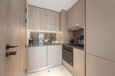 a kitchen with white cabinets and a door at Prime Location, Near Bus Stop, Steps from the Park, Just 20 Minutes to Dubai Marina - Oxford Boulevard, Jumeirah Village Circle by Deluxe Holiday Homes in Dubai