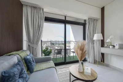 a living room with a couch and a large window at Prime Location, Near Bus Stop, Steps from the Park, Just 20 Minutes to Dubai Marina - Oxford Boulevard, Jumeirah Village Circle by Deluxe Holiday Homes in Dubai
