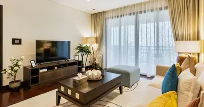 a living room with a couch and a tv at 1BR Apartment Anantara Palm Private Beach in Dubai