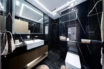 a black bathroom with a sink and a toilet at Stylish JVC Apt with Pool & Gym in Sabkhah