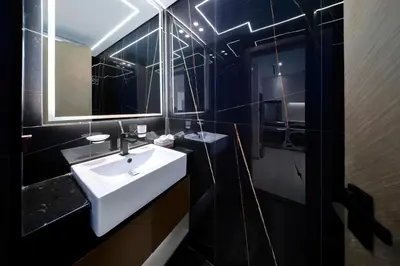 a bathroom with a white sink and a mirror at Stylish JVC Apt with Pool & Gym in Sabkhah