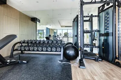 a gym with a lot of treadmills and weights at Stylish JVC Apt with Pool & Gym in Sabkhah