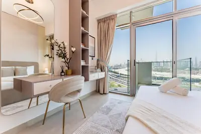 a bedroom with a desk and a large window at Full Burj Khalifa and Dubai Canal views, Minutes from Downtown and Dubai Mall - Farhad Azizi Residence, Al Jaddaf by Deluxe Holiday Homes in Dubai