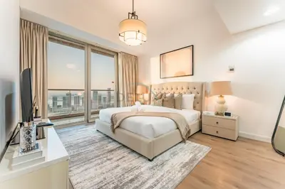 a bedroom with a bed and a large window at 3BR with Sea View, Short Stroll From Marina Walk and JBR Beach, With Easy Access to Tram and Metro - Ocean Heights, Dubai Marina by Deluxe Holiday Homes in Dubai