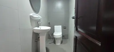 a white bathroom with a toilet and a sink at Peaceful Apartments in Dubai
