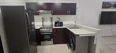 a kitchen with a black refrigerator and a sink at Peaceful Apartments in Dubai