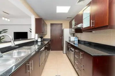 a large kitchen with a sink and a refrigerator at The Jewel Tower 2 in Dubai