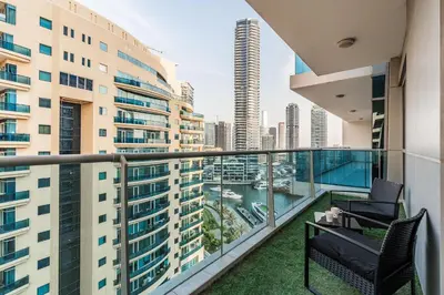 a balcony with two chairs and a view of a city at The Jewel Tower 2 in Dubai