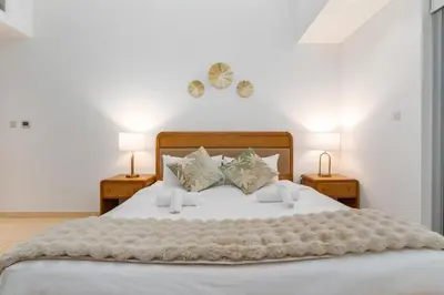 a bedroom with a large white bed with two lamps at The Jewel Tower 2 in Dubai