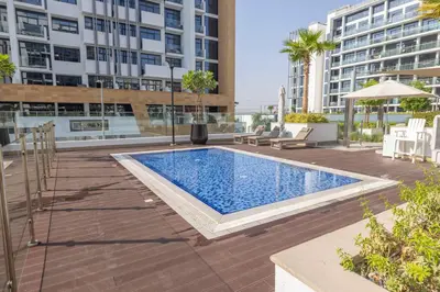 a swimming pool on the roof of a building at Cozy Apartment in Azizi Riviera - 10 min to Burj Khalifa in Dubai