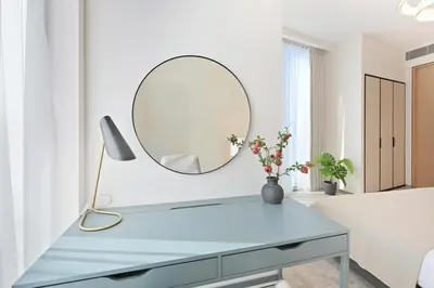 a dressing table with a mirror and a lamp at Brand New 1BD in Address JBR, Relaxing Stay for 2 in Dubai