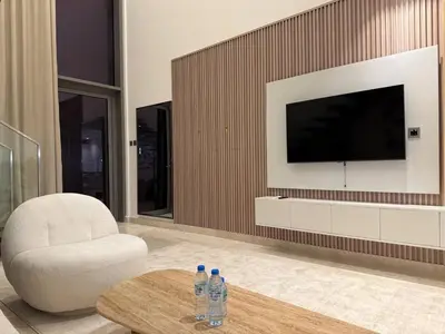 a living room with a television and two water bottles at Sterling West House in Dubai