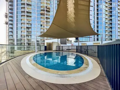 a swimming pool on the roof of a building at Vogue Al Maktoum City Sobha Hartland Waves Near to Downtown, Burj Khalifa and Dubai Mall, One Bedroom Apartment plus Kids room with Balcony and City View, Access to all Amenities in Dubai