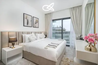 a white bedroom with a large bed and a window at Vogue Al Maktoum City Sobha Hartland Waves Near to Downtown, Burj Khalifa and Dubai Mall, One Bedroom Apartment plus Kids room with Balcony and City View, Access to all Amenities in Dubai