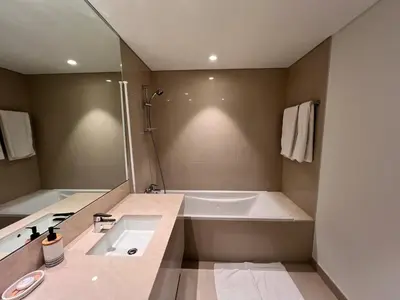 a bathroom with a large tub and a sink at Act Tower 410 in Dubai