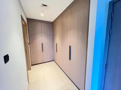 a hallway with wooden cabinets and a tile floor at Act Tower 410 in Dubai