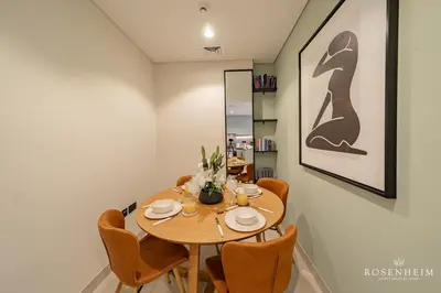 a dining room with a wooden table and chairs at Brand New 1BR - Infinity Pool & Golf Views in Dubai