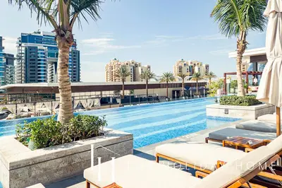 a swimming pool with chairs and palm trees on a building at LUX Iconic Views at The Palm Tower Studio 4 in Dubai