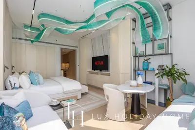a living room with two beds and a table at LUX Iconic Views at The Palm Tower Studio 4 in Dubai