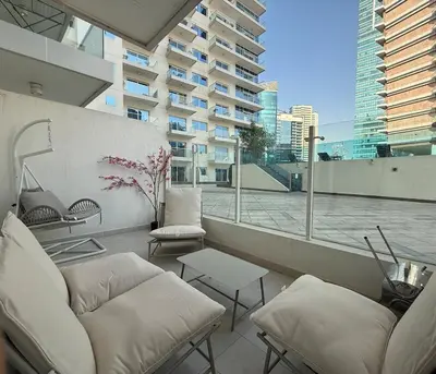 a balcony with white furniture and a view of a building at Canal View Studio AG Tower in Dubai