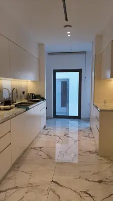 a kitchen with white cabinets and a large tile floor at World Class 6 BDR Villa In Signature Palm in Dubai