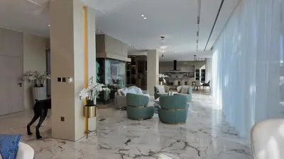 a lobby with a salon with blue chairs and tables at World Class 6 BDR Villa In Signature Palm in Dubai