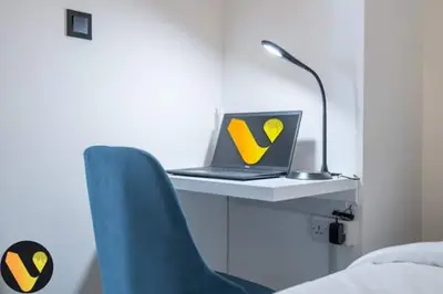 a laptop computer sitting on a desk with a blue chair at Vogue Al Maktoum City Sobha Hartland Waves Near to Downtown, Burj Khalifa and Dubai Mall, One Bedroom Apartment plus Kids room with Balcony and City View, Access to all Amenities in Dubai