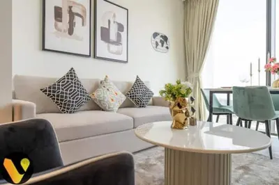 a living room with a couch and a table at Vogue Al Maktoum City Sobha Hartland Waves Near to Downtown, Burj Khalifa and Dubai Mall, One Bedroom Apartment plus Kids room with Balcony and City View, Access to all Amenities in Dubai