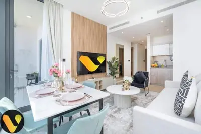 a living room with a table and chairs and a living room at Vogue Al Maktoum City Sobha Hartland Waves Near to Downtown, Burj Khalifa and Dubai Mall, One Bedroom Apartment plus Kids room with Balcony and City View, Access to all Amenities in Dubai