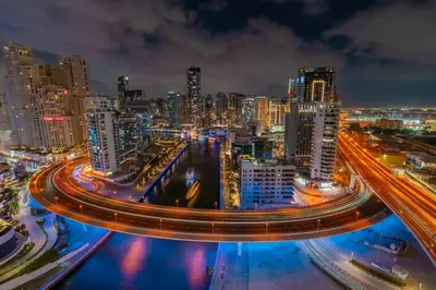 a city skyline at night with traffic on a freeway at StayShort - Luxury 1 Bedroom Apartment in Dubai Marina Sleeps 4 in Dubai