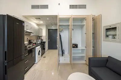 a living room with a couch and a kitchen at Chic Studio Canal Side Speedy wi-fi BBay in Dubai