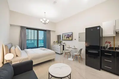 a bedroom with a bed and a living room at Chic Studio Canal Side Speedy wi-fi BBay in Dubai