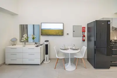 a kitchen with a table and a refrigerator at Chic Studio Canal Side Speedy wi-fi BBay in Dubai