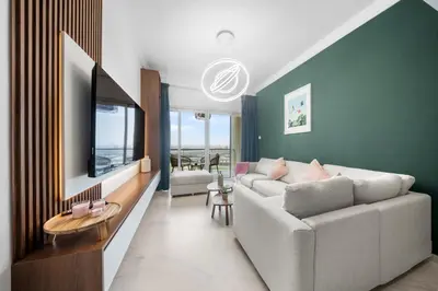 a living room with a couch and a tv at Emerald Luxury Suite DMCC Metro station in Dubai